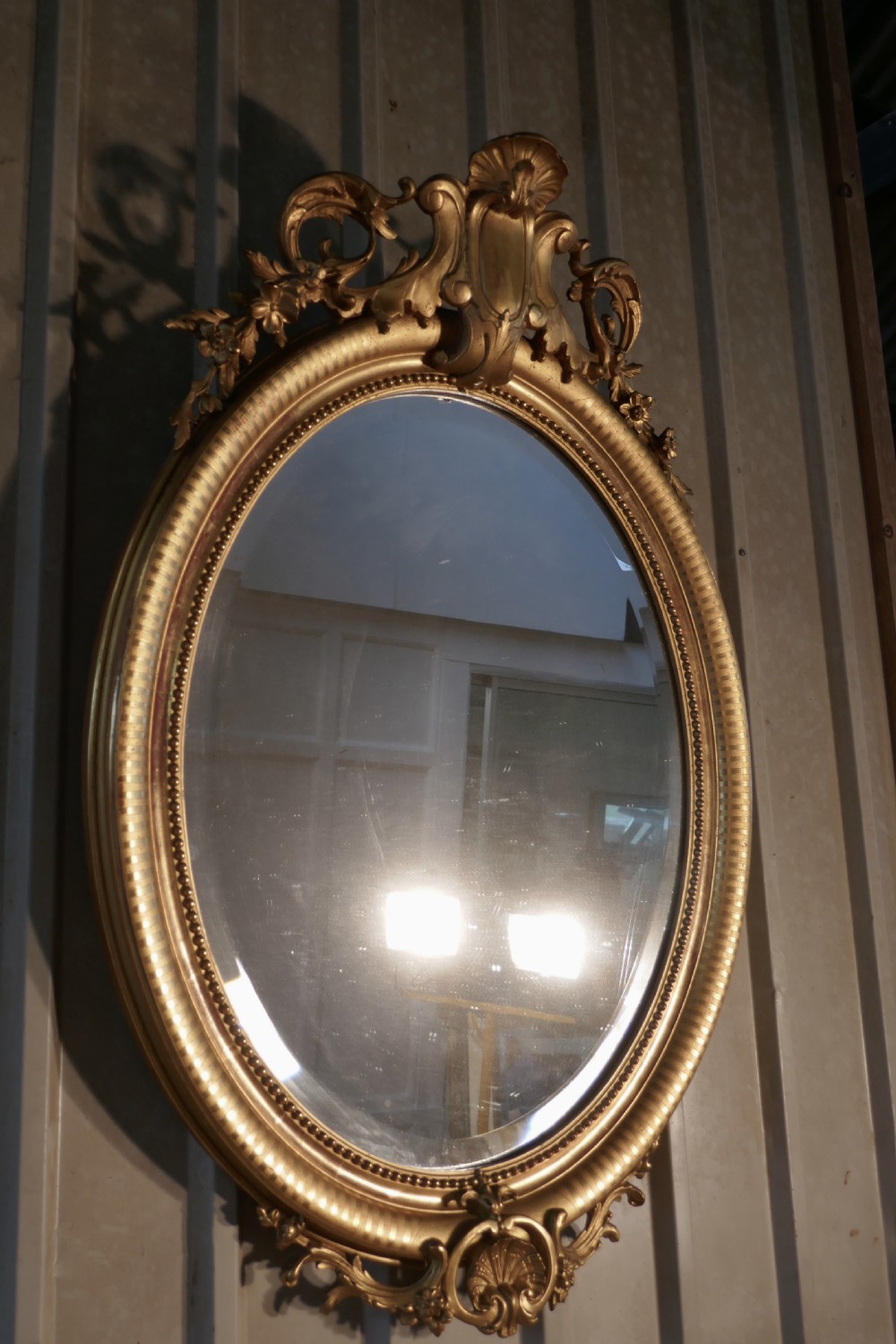 a very large french rococo oval gilt wall mirror