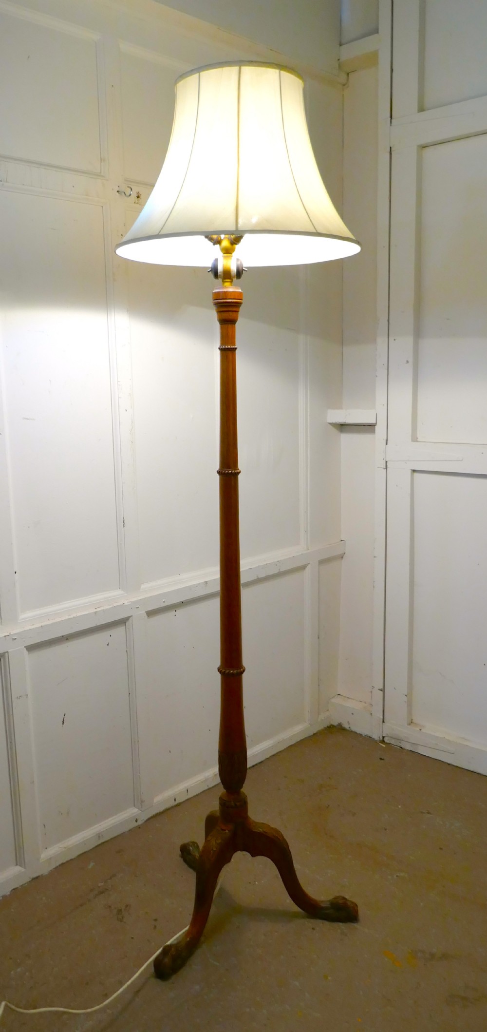a carved blonde mahogany floor standing lamp