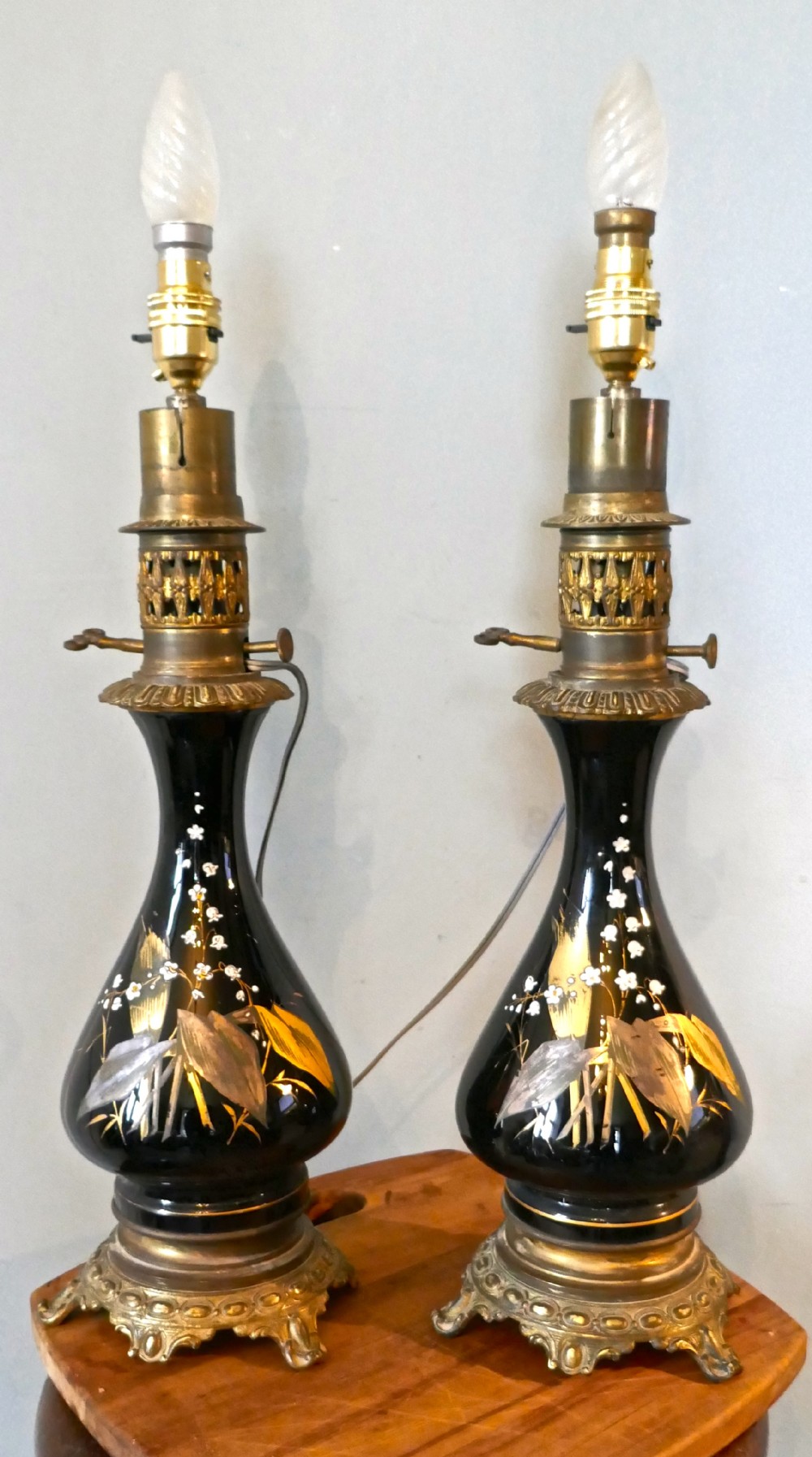a pair of victorian ceramic lamps decorated with lilly of the valley