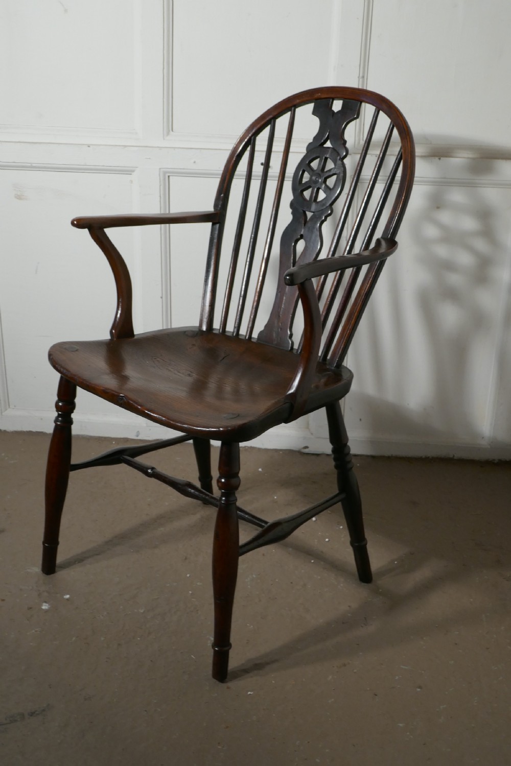 an early 19th elm wheel back carver chair