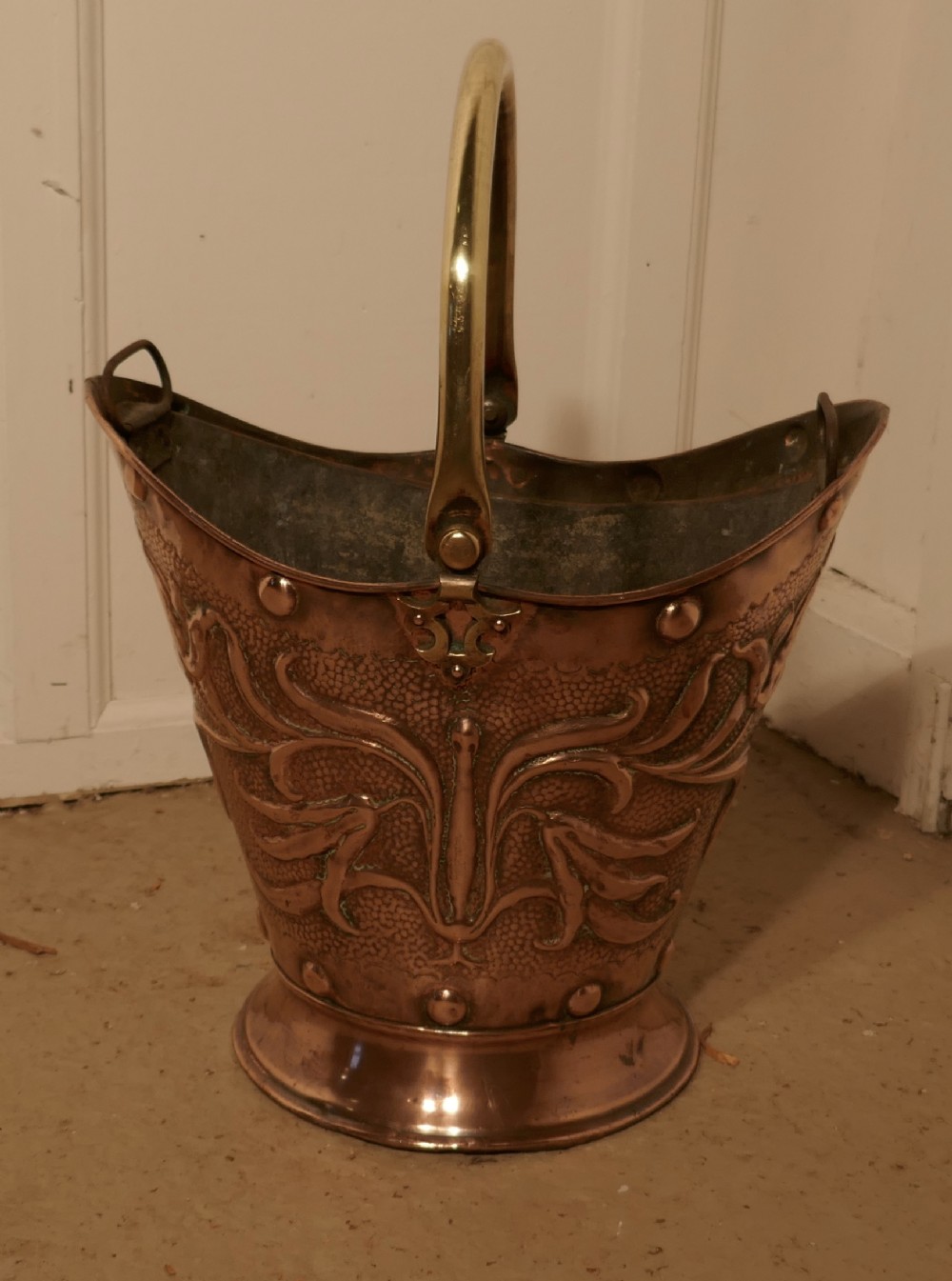 an art nouveau embossed copper helmet coal scuttle with liner