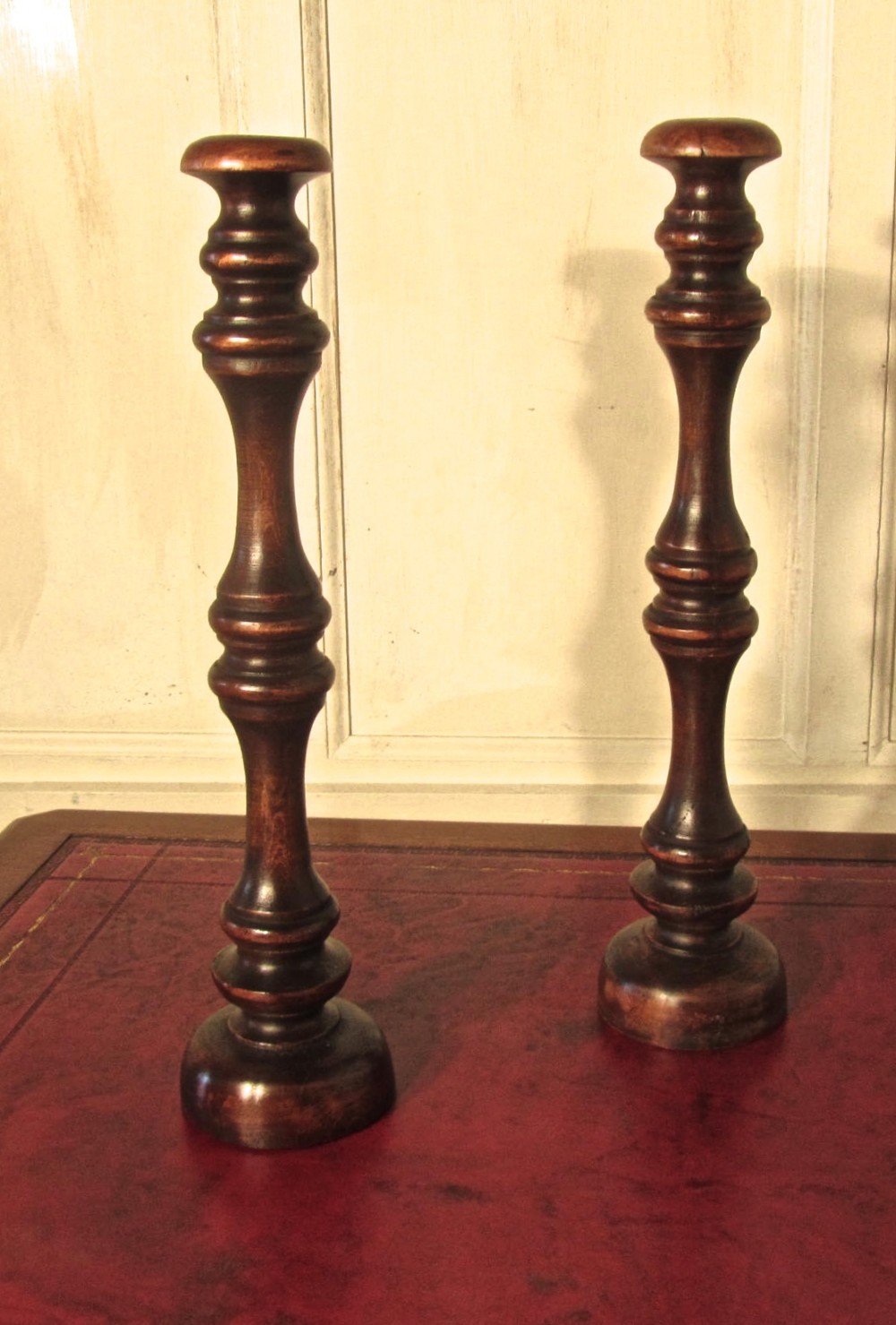 a pair of tall turned wooden wig stands shop display