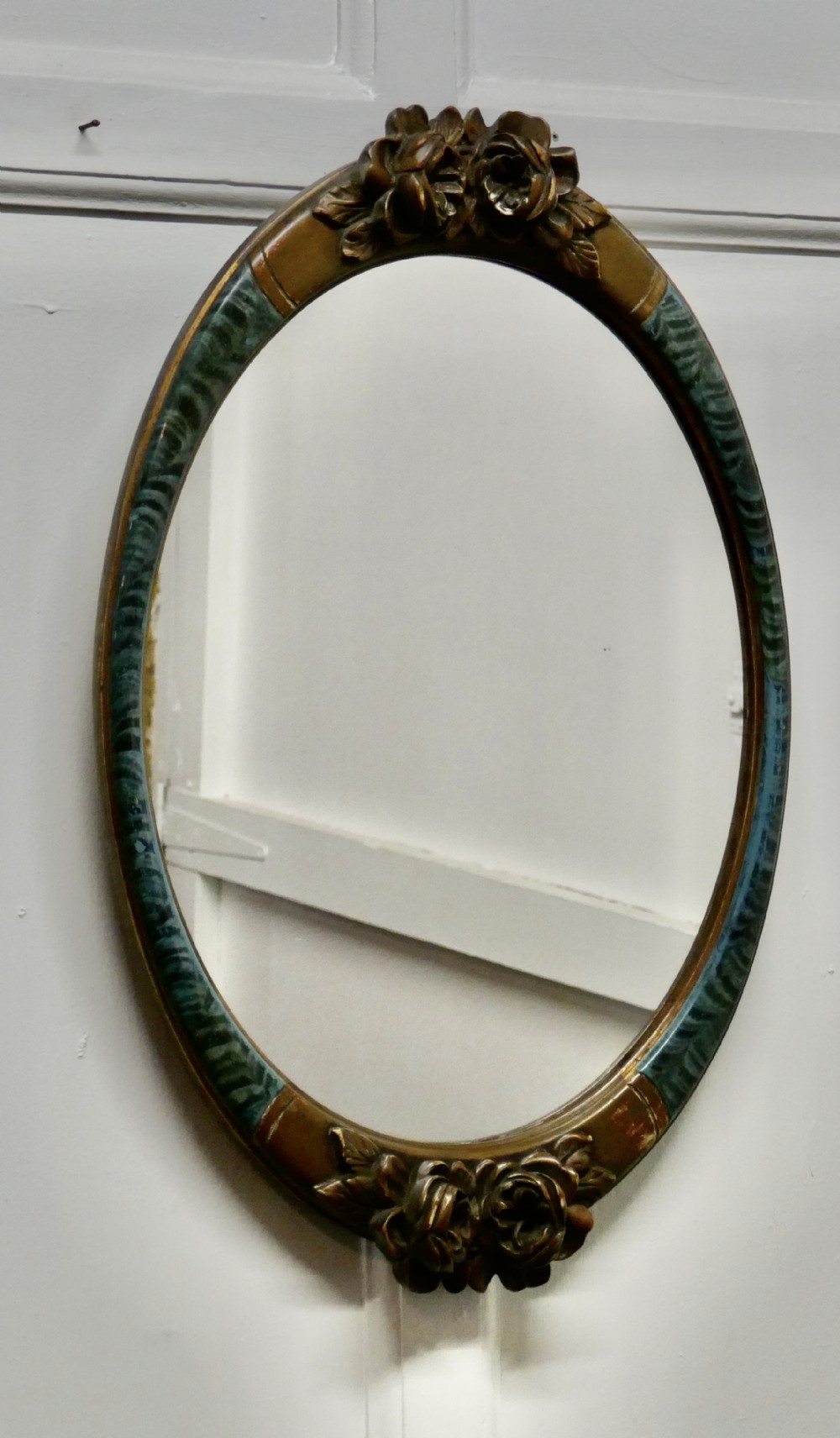 a large mirror in oval ormolu frame