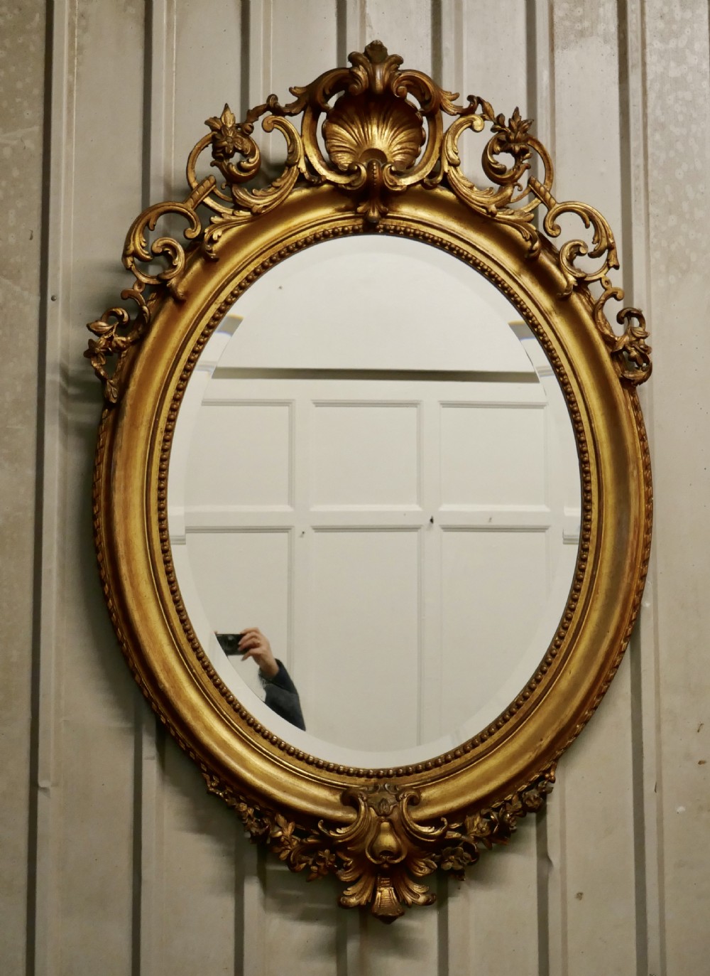 a very large french rococo oval gilt wall mirror