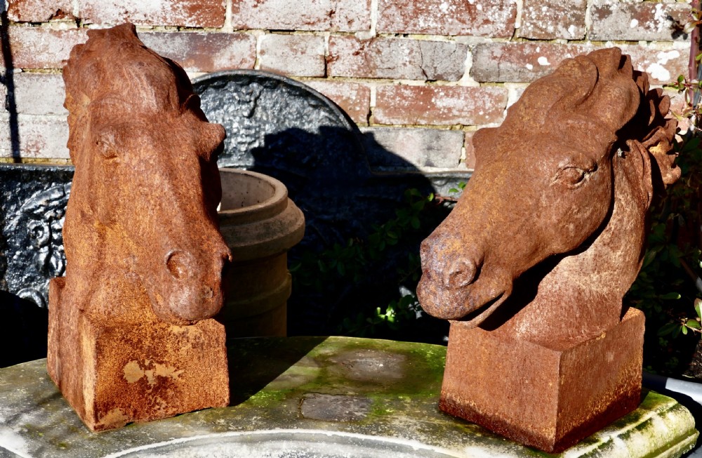 pair of large outdoor weathered cast iron horse heads