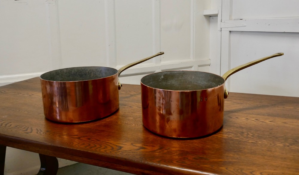 a pair of large 19th century brass handled copper pots