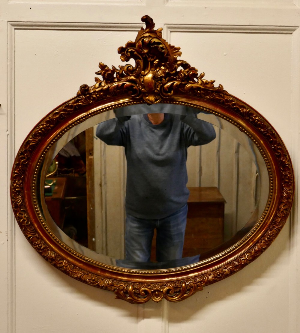 a superb late 19th century regency style oval gilt mirror