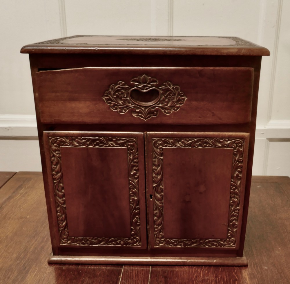 small carved cupboard with drawer