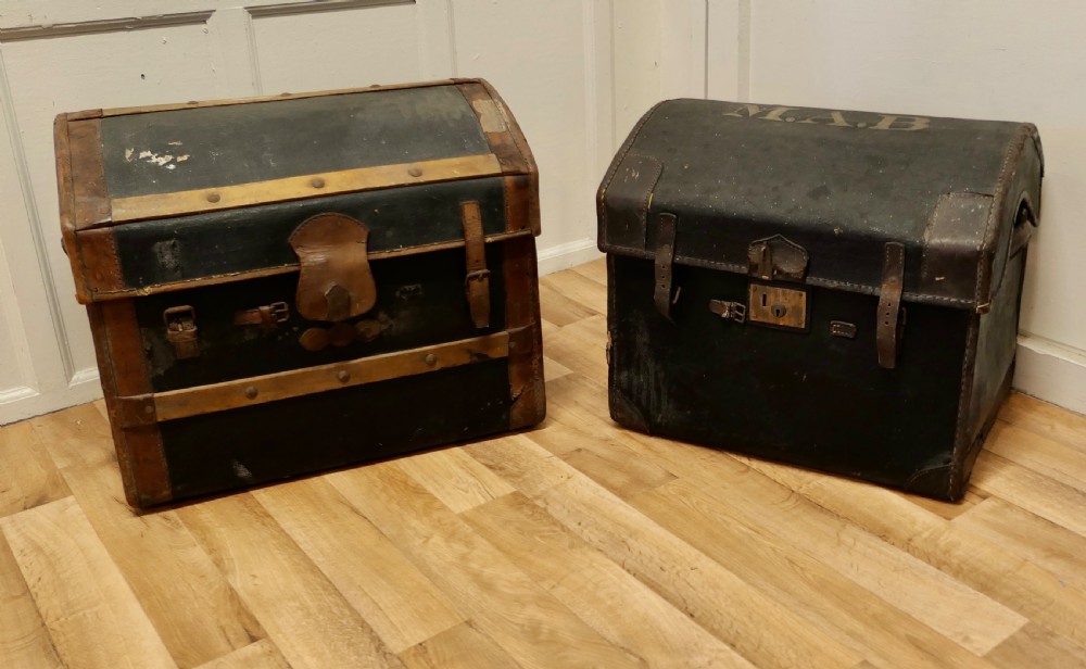 a pair of victorian canvas and leather dome top travel trunks