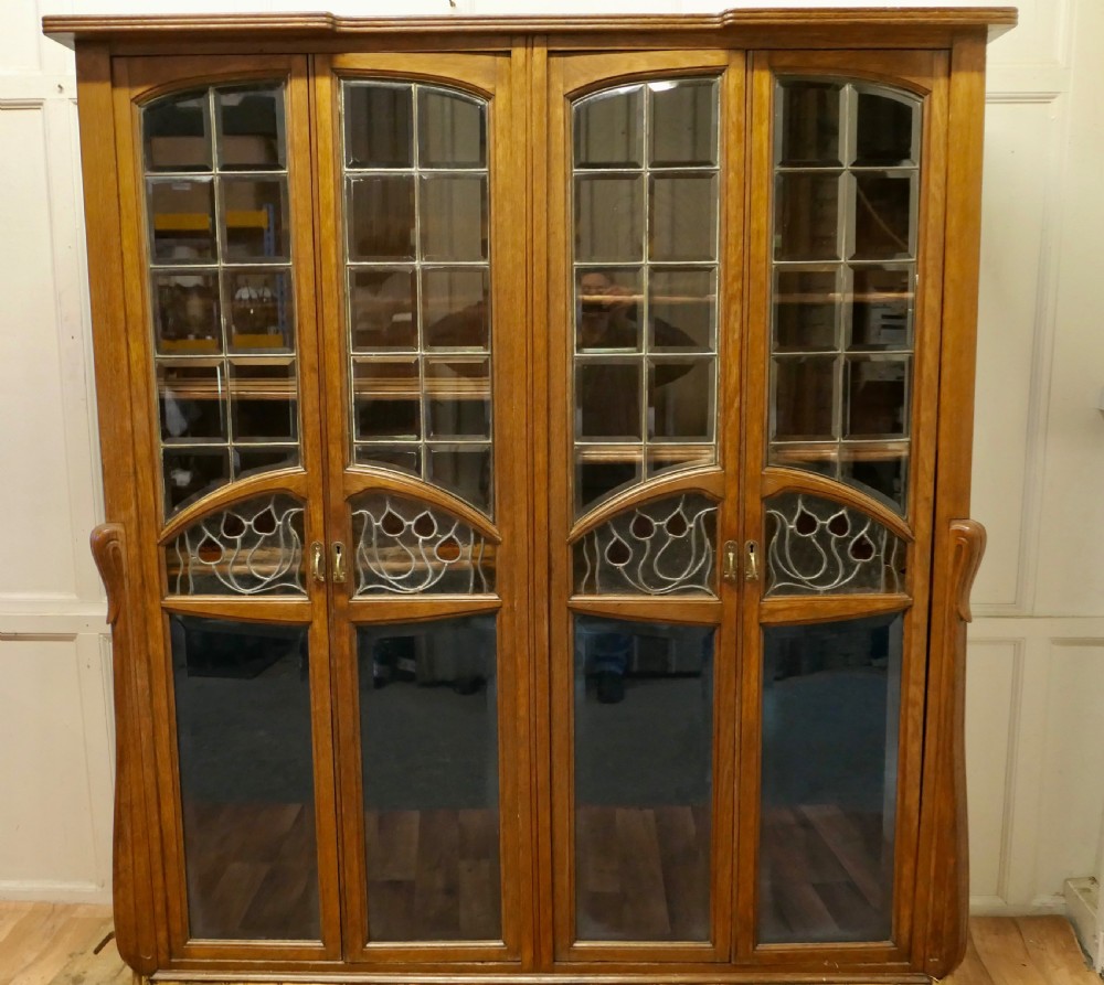 a rare piece of progressive arts and crafts furniture in golden oak and stained glass