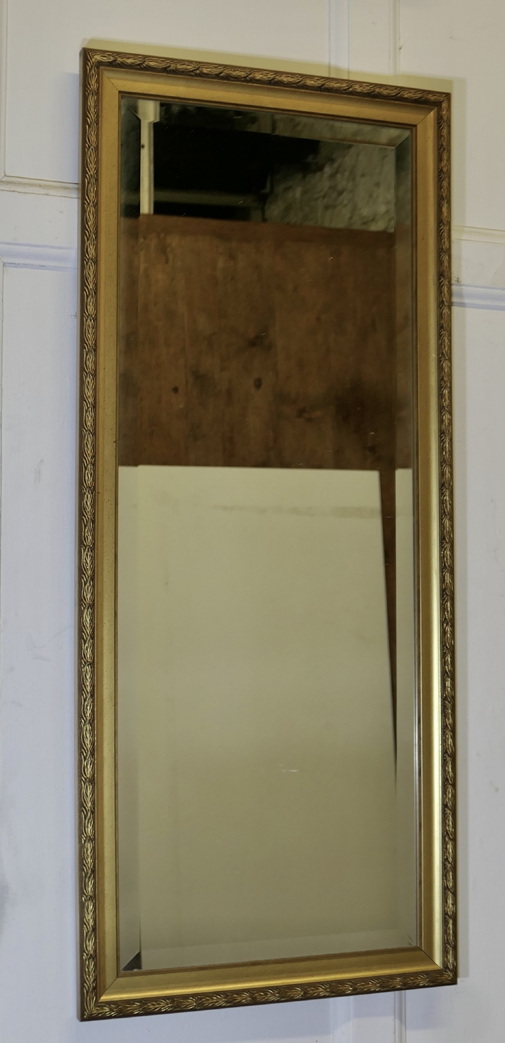 a decorative long narrow gilt dressing mirror