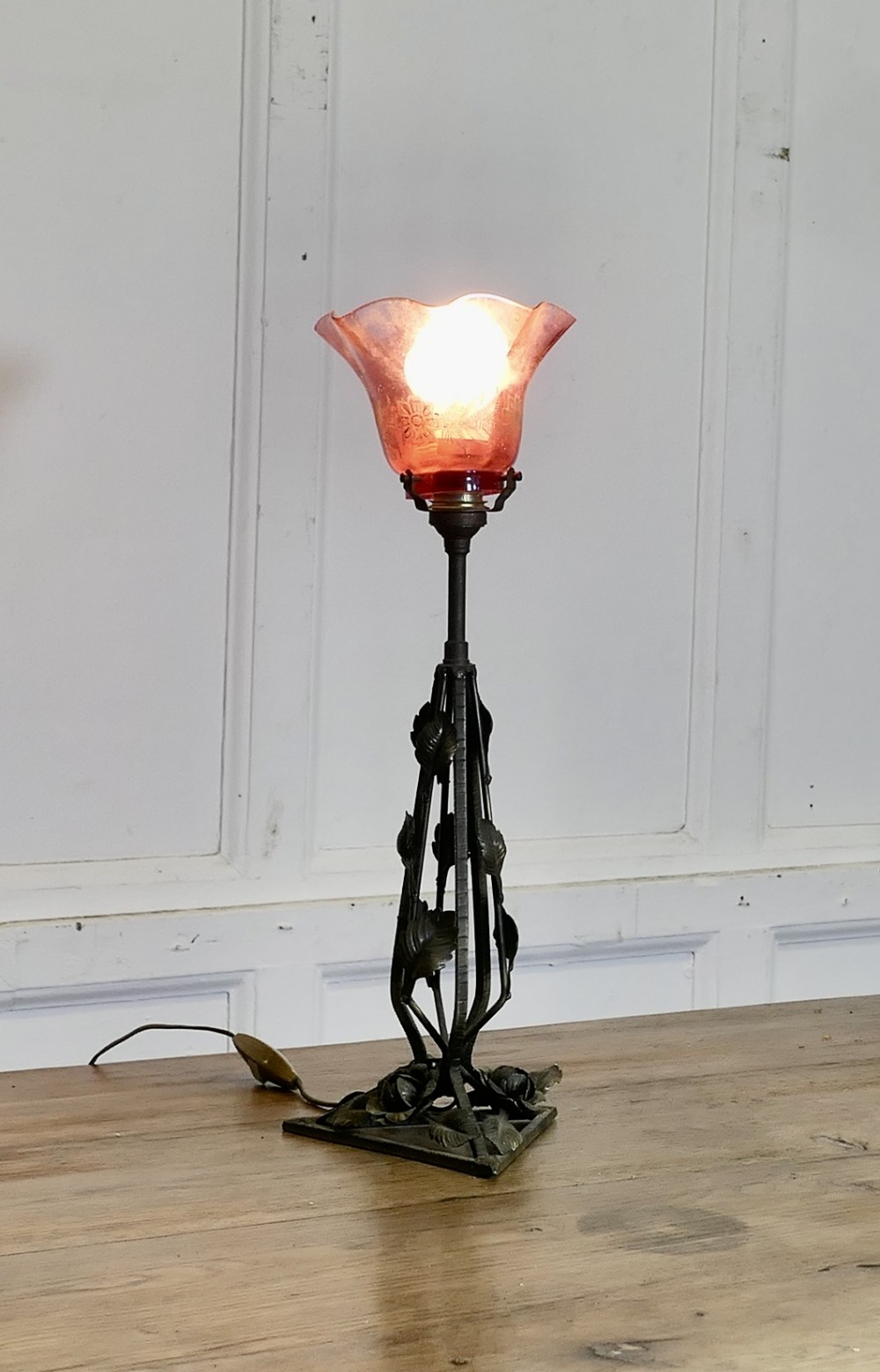 french iron and toleware lamp with ruby and gold leaf glass shade