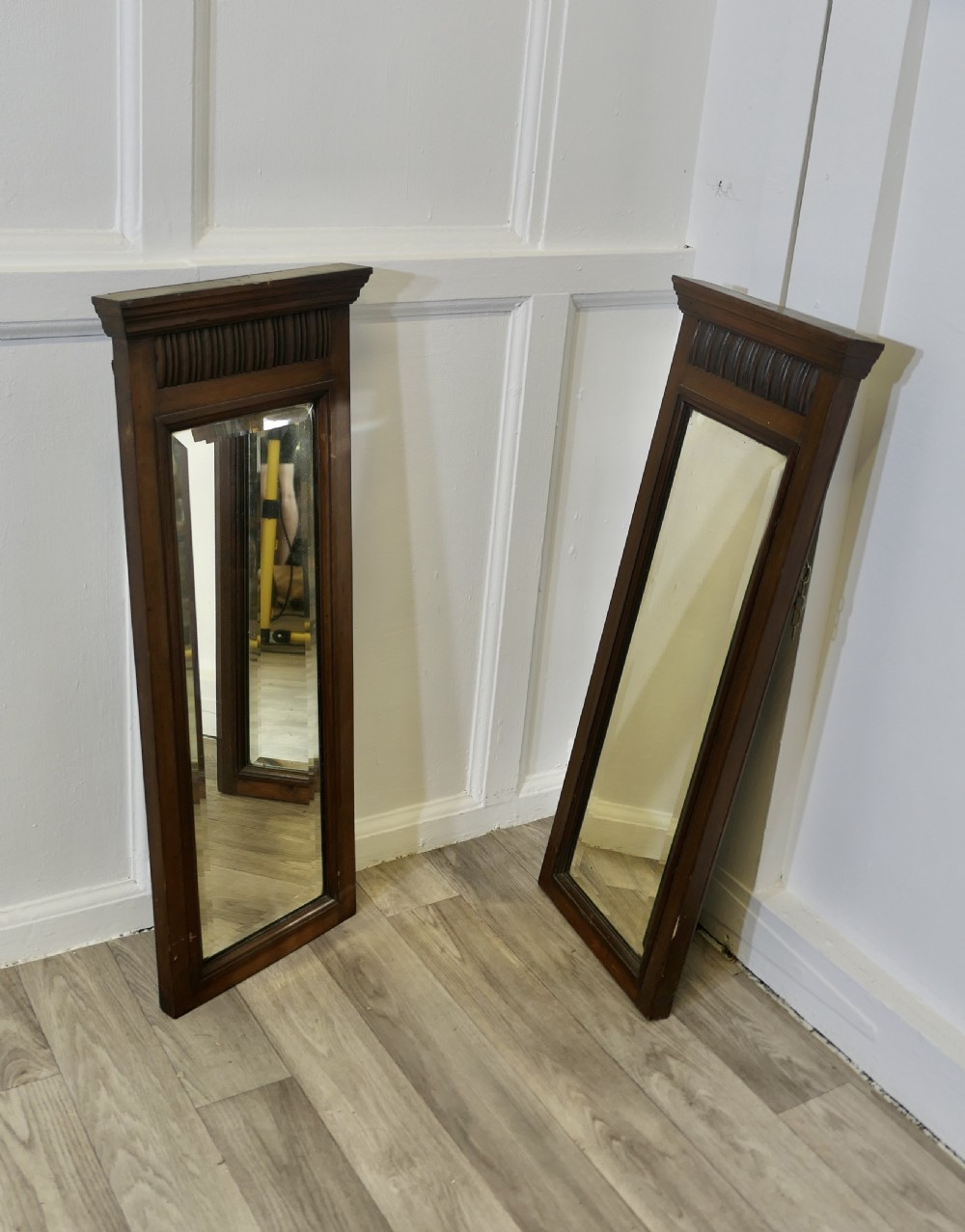 a pair of narrow edwardian walnut mirrors