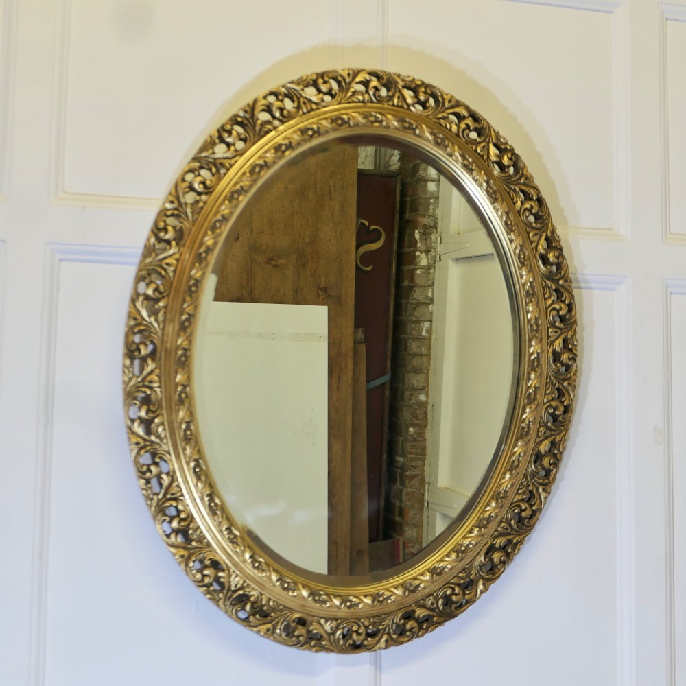 carved oval gilt wall mirror