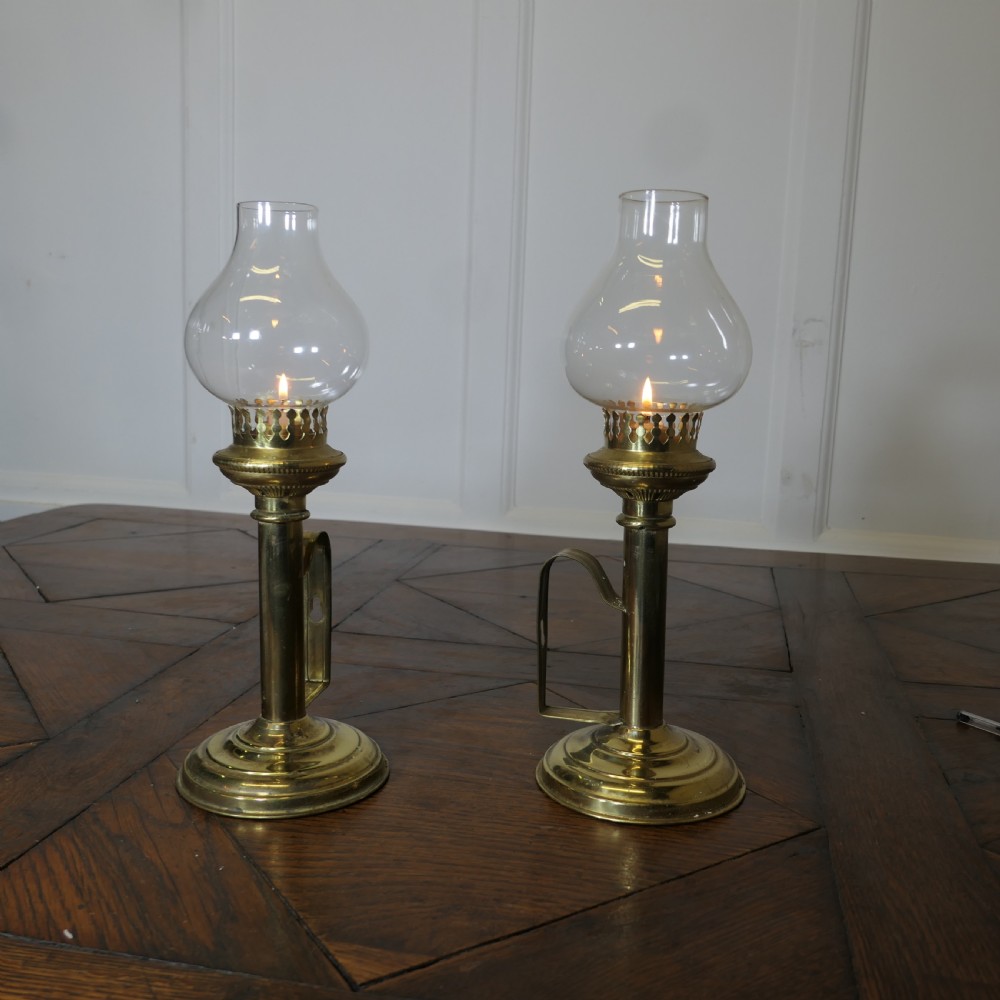 pair of brass candlesticks with glass chimneys