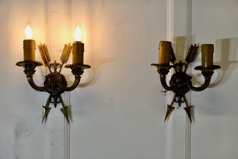 an unusual pair of french brass twin wall lights with arrows