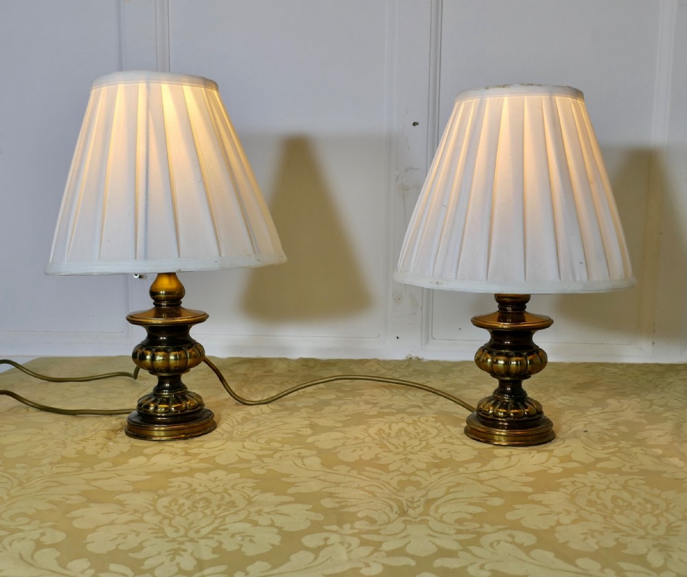 a pair of chunky brass bedside lamps